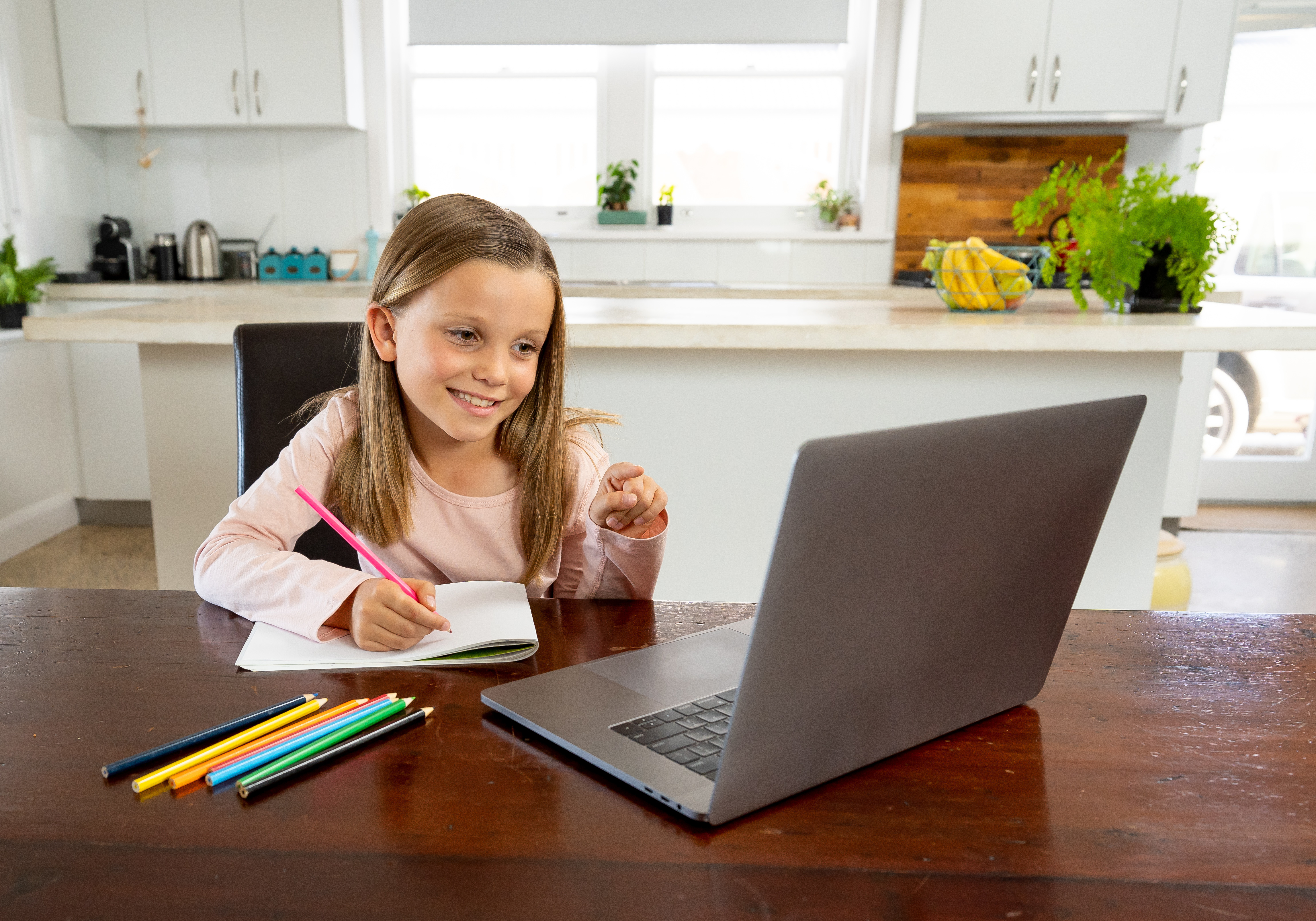 Image of a girl smiling at a laptop doing some paperwork