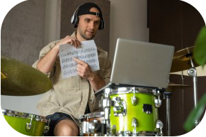 Image of smiling male drum tutor showing music